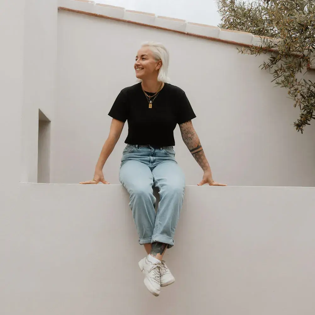 Buchhaltungsmentorin Melanie Göggel auf einer Mauer sitzend.