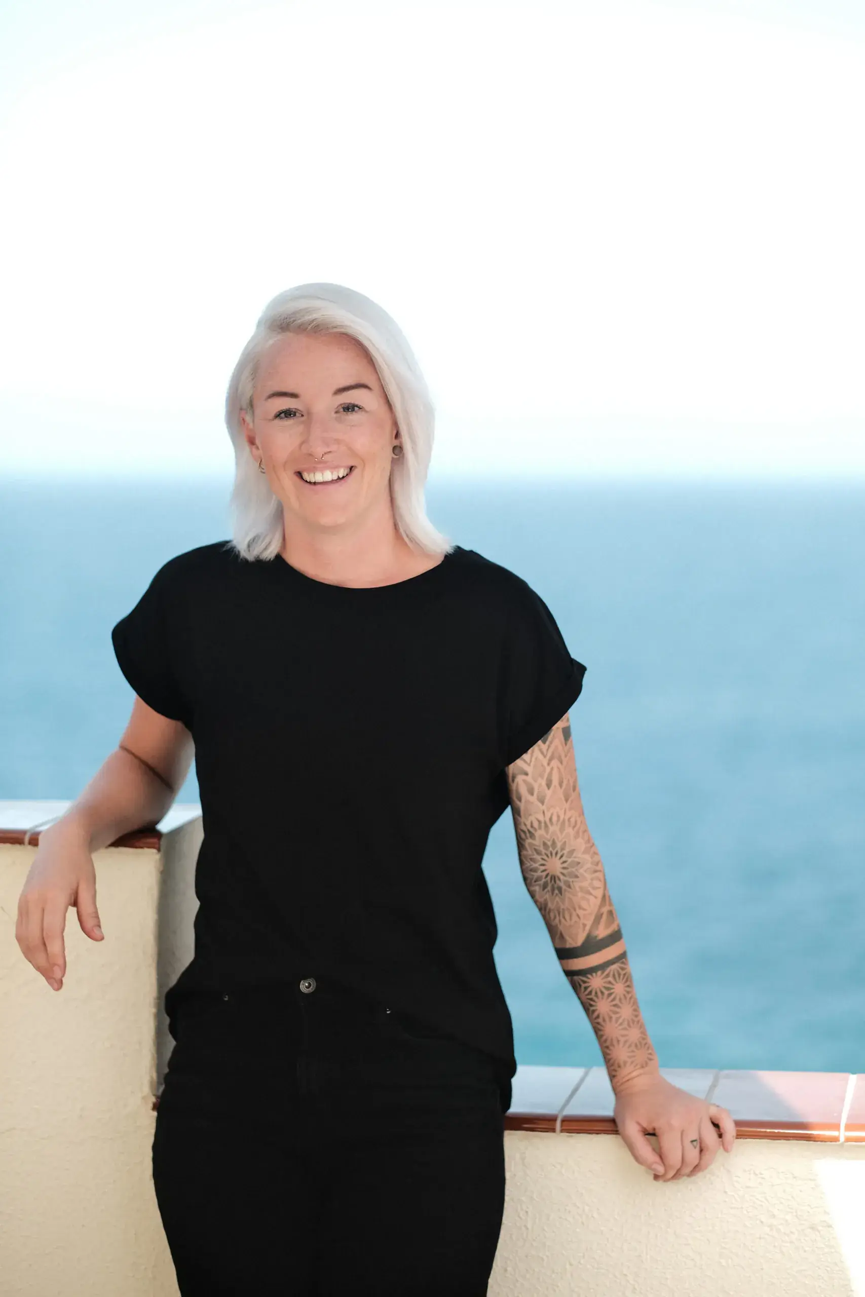 Melanie Göggel, Buchhaltungsmentorin und ehemalige Steuerfachangestellte, steht lächelnd vor dem offenen Meer.